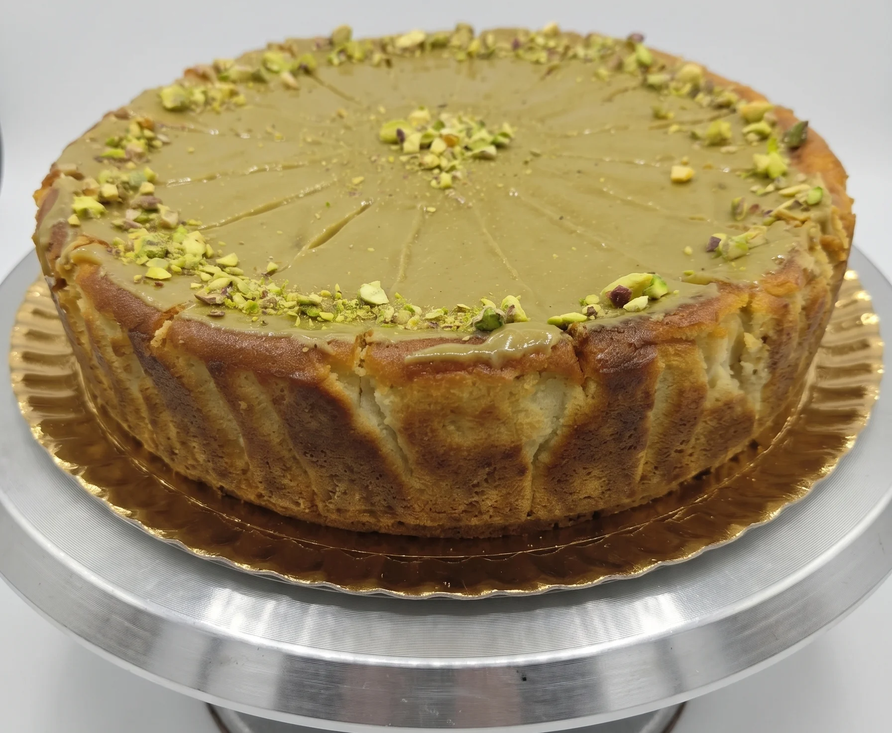 Tarta cremosa de queso y pistacho con bordes tostados y centro fundente